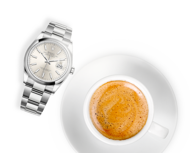 Rolex watch next to a coffee